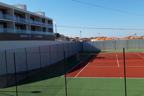 纳扎雷Brisa do Mar Ap.的一座网球场,在一座大楼前设有网