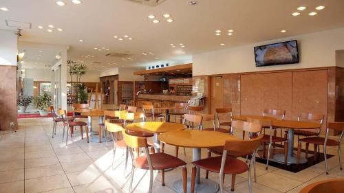 山口Toyoko Inn Shin-yamaguchi-eki Shinkansen-guchi的一间在房间内配有桌椅的餐厅