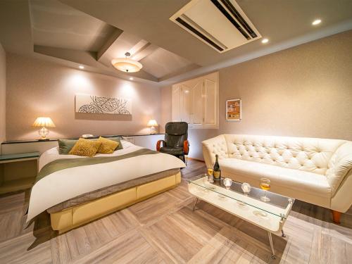 堺市QT仙北酒店（仅限成人） 的一间卧室配有一张床和一张沙发
