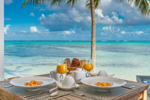 莫雷阿Moorea Island Beach Hotel的海滩上的一张桌子,早餐在海边