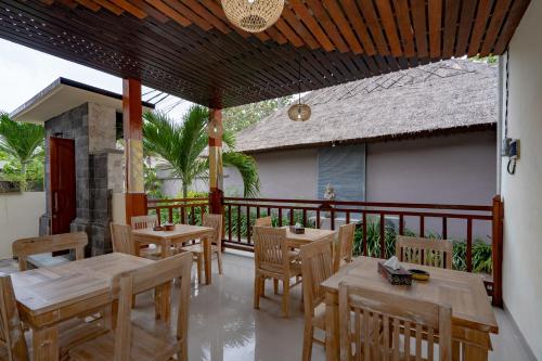 蓝梦岛The Pulau Bungalow的阳台餐厅,配有木桌椅