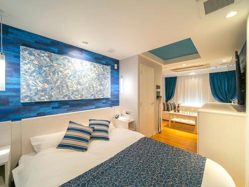 泉南市关西机场GT酒店（成人专用）的一间卧室配有一张蓝色墙床