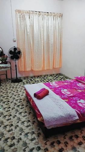 KodiangHOMESTAY UMI KODIANG的一间卧室配有一张带粉色床单的床和一扇窗户。