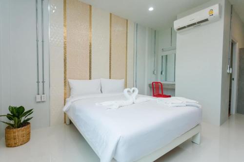 Ban Pho TaiGet Sleep @ท่าศาลา的红色椅子的房间里一张白色的床
