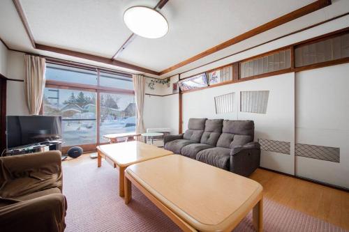 旭川GUESTHOUSE CHIYOGAOKA的客厅配有沙发和桌子