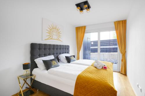 菲拉赫CT-GOLD Apartments - Villach Malina - nahe Atrio und Therme的一间卧室配有一张带黄色毯子的大床