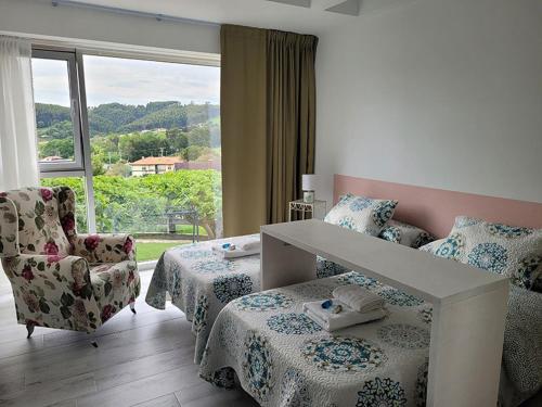 MiengoLa Casuca de Mamina的一间卧室设有两张床、一把椅子和一个窗户。