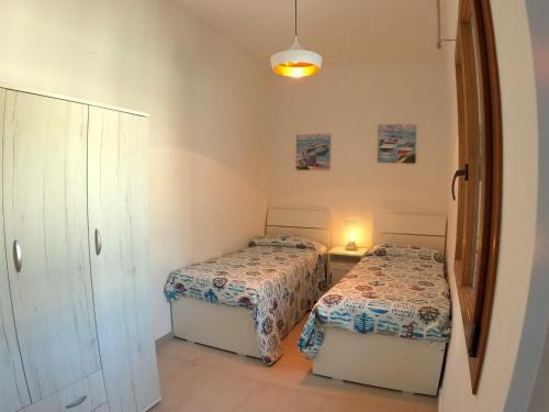 费拉约港Appartamento Marina的一间卧室配有两张床和镜子