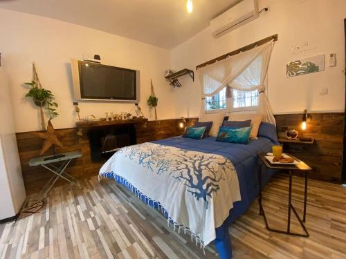 梅利利亚Beach house MAREA CORAL的卧室配有一张床,墙上配有电视。