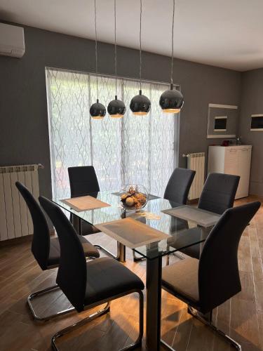 奥帕提亚Kuća za odmor Viktoria的一间设有玻璃桌和椅子的用餐室