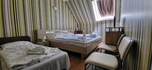 希欧福克科罗纳酒店 的一间卧室设有两张床、一把椅子和一个窗户。