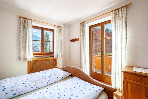 MontechiaroHof am Schloss Apartement Enzian的一间卧室设有一张床和两个窗户。