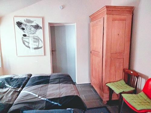 NonnweilerZelfies Kunstapartment.的一间卧室配有一张床和一个木制橱柜