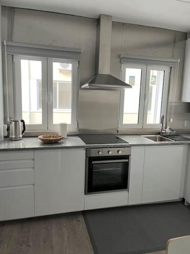 纳扎雷Casa Mar Azul的厨房配有白色橱柜和炉灶烤箱。