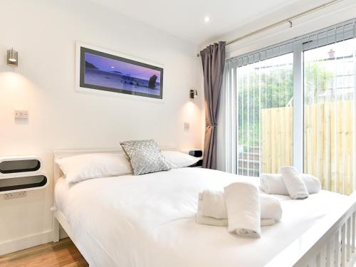 斯旺西Pass the Keys Newly Renovated Bungalow - Stunning views of Gower的卧室设有一张白色大床和一扇窗户。
