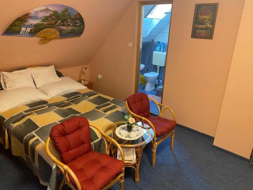 下帕霍克兹索利旅馆的一间卧室配有一张床、两把椅子和一张桌子