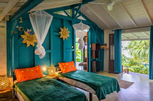 黑角TropicAngel ECOLODGE de Charme的蓝色墙壁客房的两张床