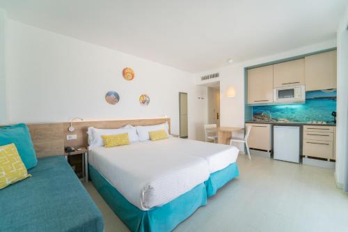 阿尔库迪亚港Apartamentos Ferrer Lime Tamarindos的一间带大床的卧室和一间厨房
