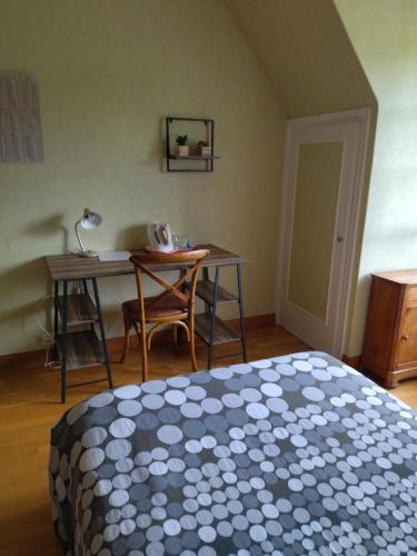 高伊斯瑙Chambre Solo Grande maison的一间卧室配有一张床、一张桌子和一张书桌