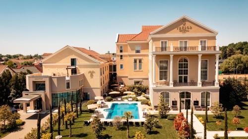蒂米什瓦拉Hotel Tresor Le Palais的一座大房子,前面设有一个游泳池