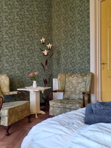 斯塔茨卡纳尔B&B Villa de Beuk的一间卧室配有一张床、两把椅子和一张桌子