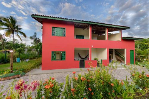 库穆鲁沙蒂巴Casarão das artes hospedaria的前面有花园的红色房子