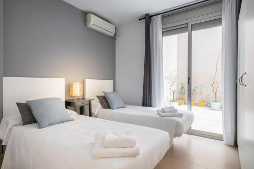 巴塞罗那Inside Barcelona Apartments Salva的带窗户的客房内的2张白色床