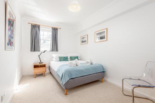 圣安德鲁斯Abbey Street - 2 bedroom - Central的白色卧室配有床和椅子
