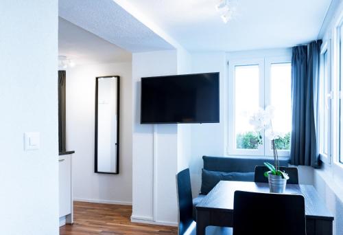 苏黎世HITrental Wiedikon Apartments的客厅配有桌子和电视