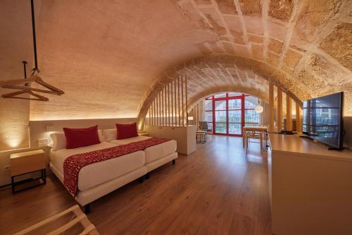 马略卡岛帕尔马Fil Suites的一间卧室配有一张床,并在一间客房内配有电视。