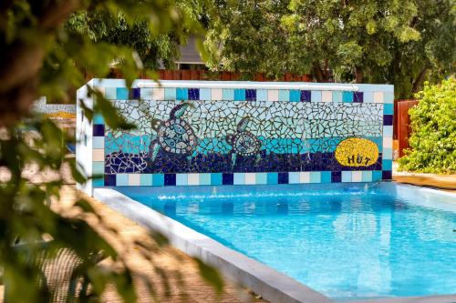 克拉伦代克The Hut Bonaire的游泳池旁设有马赛克墙