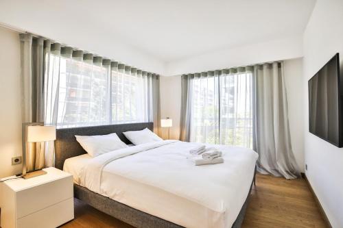尼斯Sublime Appartement Promenade des Anglais (2)的卧室设有白色大床和窗户。