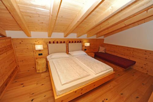 奥蒂塞伊Mountain Apartment Hapeli的木制客房内的一间卧室配有一张大床