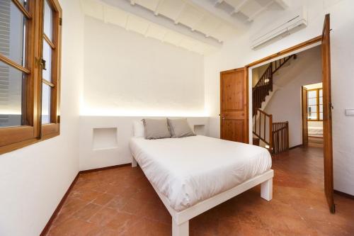 休达德亚SANT ISIDRE 50的卧室配有白色的床和楼梯。