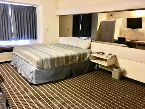 沙德伦Chadron Inn & Suites的酒店客房,配有床和电视