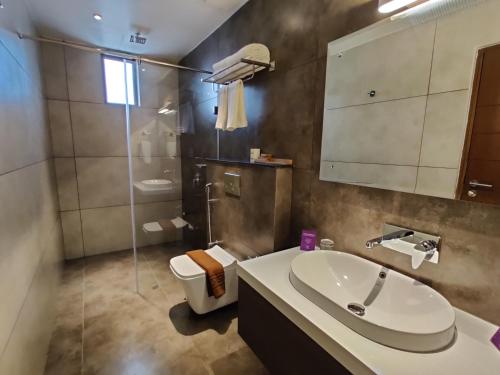 尼杜巴塞莱Florida Airport Hotel Kochi的一间带水槽、卫生间和镜子的浴室