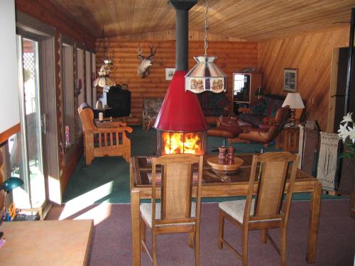 坎卢普斯Kamloops Log Home Bed and Breakfast的客厅设有带壁炉的桌子