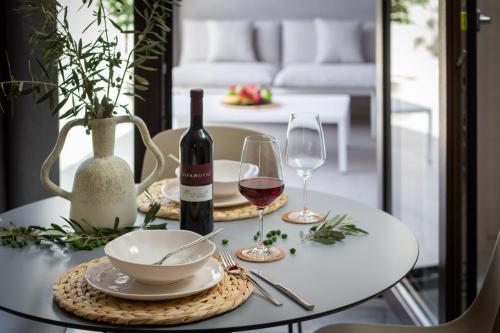 科米扎Residence THE ONE - new的一张带葡萄酒瓶和玻璃杯的白色桌子