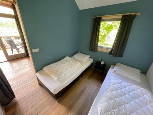 BeilenTrekkershut - 4 personen的一间卧室配有两张床和镜子