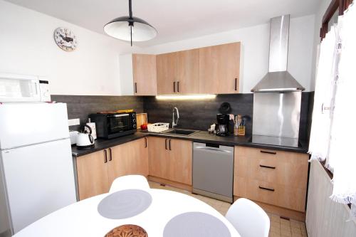 布里昂松Coquet appartement Type 2 de 56 m² en centre ville的厨房配有木制橱柜和白色冰箱。