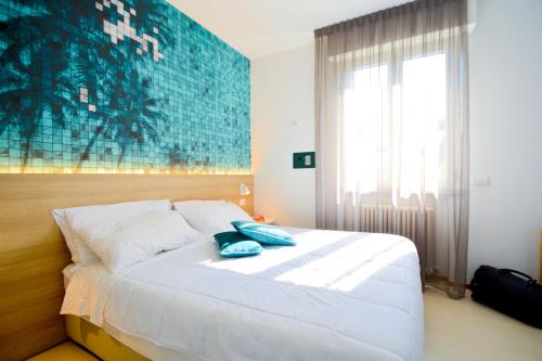 里乔内Prime Blue Suite - Appartamenti con jacuzzi privata的卧室配有带蓝色枕头的大型白色床
