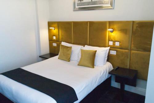 布莱克浦The Bromley的酒店客房配有一张带黄色枕头的大型白色床。