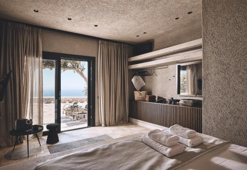 ProvatasNoma Milos - Delmar Collection的一间卧室配有一张床,享有海景