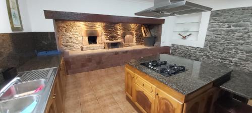 桑塔纳Paraíso Resiliente的厨房配有墙上的石炉