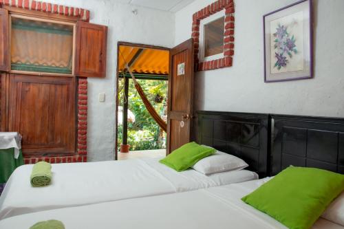 洛斯纳兰霍斯Entre Bosques Tayrona的配有绿色枕头的客房内的两张床