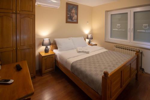 拉克塔希Motel Atos的一间卧室配有一张床、两盏灯和一个窗户。