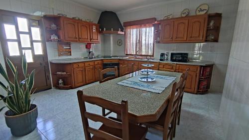 Casa Araújo的厨房配有木制橱柜和桌椅