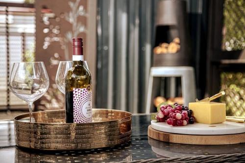 玛塔玛塔HOH - Hazel's Boudoir的一张桌子上摆放着一瓶葡萄酒和酒杯