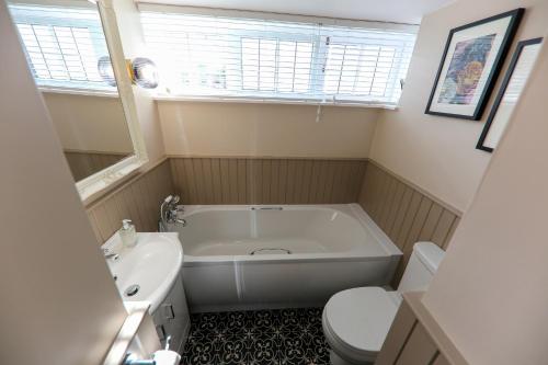 梅尔罗斯Postbox Cottage的带浴缸、卫生间和盥洗盆的浴室