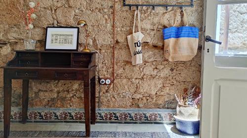 大加那利岛拉斯帕尔马斯Adara Vegueta Exclusive Apartment的一间设有桌子和一扇带窗户的石墙的房间